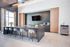 Modern communal kitchen with sleek countertops, elegant bar seating, and a stylish coffee station, perfect for social gatherings.