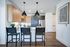Modern kitchen with sleek cabinetry, stylish pendant lighting, and elegant black bar stools, offering a chic and inviting atmosphere.