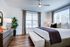 Inviting bedroom featuring a spacious bed, elegant decor, and abundant natural light through large windows.