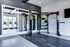 Modern apartment gym featuring state-of-the-art equipment, including treadmills and a versatile weight training setup, with bright natural lighting.