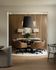 Sophisticated dining area with modern chairs around a round table, chic pendant lighting, and elegant artwork on a wooden accent wall.