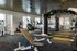 Modern fitness center with state-of-the-art equipment, including treadmills, weight benches, and a punching bag, designed for optimal workout experiences.