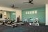 Inviting fitness center with modern exercise equipment, vibrant motivational wall art, and spacious mirrored walls.