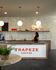 Chic coffee shop with elegant lighting, modern decor, and Trapeze Coffee branding on the counter, featuring a welcoming atmosphere.