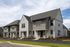 Charming modern townhomes with elegant gabled roofs and inviting porches in a serene neighborhood setting.