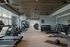 Modern, spacious fitness center featuring state-of-the-art exercise equipment, weights, and large windows with natural light.