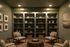 Elegant home library with sophisticated bookshelves, modern armchairs, and stylish decorative elements in warm ambient lighting.
