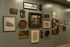 Eclectic gallery wall showcasing diverse framed art and decor pieces on a stylish green paneled wall, creating an inviting and inspiring space.
