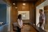 Elegant reception area with warm wood paneling, modern artwork, and welcoming staff, creating a professional and inviting atmosphere.