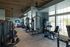 Modern fitness center with state-of-the-art exercise machines, large windows offering natural light, and sleek wooden ceiling design.