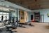 Spacious fitness center featuring modern equipment, free weights, and ample natural light for an energizing workout experience.