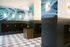Modern apartment mailroom with artistic wall design, sleek black mailboxes, and elegant tile flooring for a chic and welcoming atmosphere.