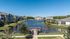 Scenic apartment complex with lush greenery and a serene water view, featuring modern buildings and a charming boardwalk.