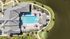 Stunning aerial view of a luxurious poolside oasis with vibrant umbrellas, surrounded by lush greenery and a serene lake.