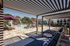 Luxurious outdoor pool area with stylish lounge chairs, vibrant purple umbrellas, and relaxing cabanas.