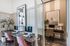 Modern home office with sleek workstations, stylish artwork, and lush greenery, offering a professional and inviting atmosphere.
