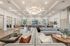 Spacious and elegant living area featuring modern furnishings, abundant natural light, and a stunning central chandelier.