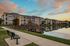 Beautiful lakeside apartment complex at sunset with modern architecture and serene water views.