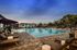 Luxurious outdoor pool area with stylish lounge chairs and elegant cabanas, perfect for relaxation under the blue sky.