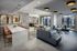 Contemporary open-concept living area with plush seating, modern art, and sleek pendant lighting, perfect for entertaining.