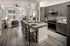 Modern open-concept apartment featuring a stylish kitchen with granite countertops, sleek grey cabinets, and a cozy living area with contemporary decor and abundant natural light.