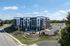 Modern apartment complex with stylish architecture and beautifully landscaped surroundings, featuring ample parking and scenic views.