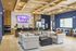 Modern open-concept living space with cozy seating, a stylish wooden ceiling, and a sleek kitchen bar. Vibrant decor and ample natural light create an inviting atmosphere.