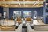 Chic and modern living area with elegant wooden ceiling, plush seating, and a vibrant blue accent wall, offering ample natural light through large windows.