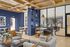 Stylish apartment common area with sleek modern furniture, vibrant blue accents, and wooden ceiling, ideal for social gatherings.
