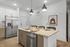 Modern kitchen with sleek stainless steel appliances, elegant pendant lighting, and a stylish breakfast bar with contemporary seating.