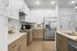 Modern kitchen design featuring sleek stainless steel appliances, elegant white cabinetry, and a spacious island countertop.