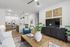 Modern living area with open-concept kitchen, featuring sleek cabinetry, stainless steel appliances, and a cozy sitting space accented by stylish decor and lush greenery.