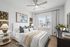 Elegant bedroom with contemporary decor, featuring a plush bed, sleek furnishings, and a large window offering plenty of natural light.