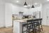 Modern kitchen with sleek white cabinetry, stainless steel appliances, and a stylish island with black pendant lighting and bar seating.