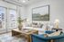 Bright and cozy living room with elegant decor, featuring a comfortable white sofa, modern artwork, and a stylish wooden coffee table.