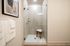Elegant bathroom featuring a modern glass shower with stylish decor and plush towels.