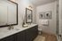Elegant bathroom with dual sinks, modern fixtures, stylish cabinets, and tasteful wall art, offering a serene and contemporary ambiance.