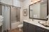 Elegant bathroom with modern fixtures, featuring a spacious vanity, large mirror, and relaxing tub with subtle lighting.