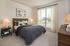 Inviting bedroom with abundant natural light, featuring a cozy bed, elegant decor, and an airy window view.