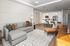 Chic and modern open-concept living room with a cozy sectional sofa, elegant kitchen with bar seating, and stylish decor.