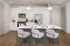 Modern kitchen with sleek white cabinetry, stainless steel appliances, and a stylish island with elegant seating.