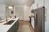 Modern kitchen with stainless steel appliances, sleek countertops, stylish lighting, and ample storage space.