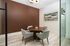 Elegant conference room with a sleek round table, cushioned chairs, and modern decor, perfect for productive meetings.