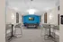 Modern recreational room featuring a sleek pool table, comfortable seating, and a vibrant blue accent wall with a mounted TV.