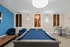 Chic recreation room with a sleek pool table, cozy seating area, and stylish bar stools, perfect for entertaining.