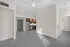 Modern apartment interior with an inviting open floor plan, showcasing sleek stainless steel kitchen appliances and ample natural light through large windows.