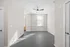 Bright, modern living space with sleek ceiling fan, large window, and stylish gray flooring.