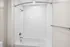 Bright and modern bathroom featuring a sleek, curved shower curtain rod and elegant white tile design.