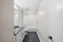 Sleek modern bathroom with elegant granite countertop, contemporary fixtures, and a pristine bathtub surrounded by stylish white tiles.
