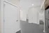 Modern apartment with sleek finishes featuring a bright hallway, spacious doors, and a glimpse of a stylish bathroom and kitchen.